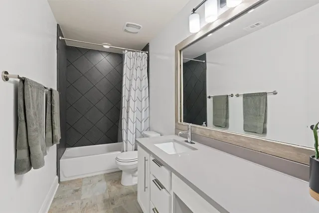 a bathroom with a double vanity sink toilet and shower