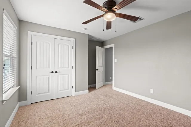 an empty room with chandelier fan