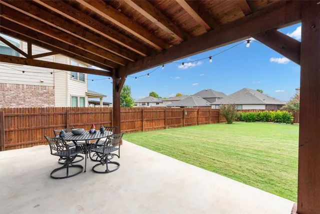 a view of a patio with table and chairs and garden view