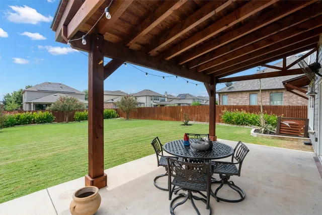 a view of a patio with a table chairs and a backyard