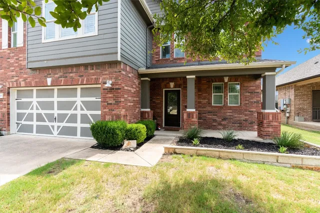 a front view of a house with a yard and potted plants