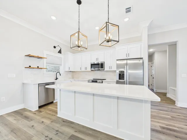 a kitchen with stainless steel appliances a stove a sink and refrigerator