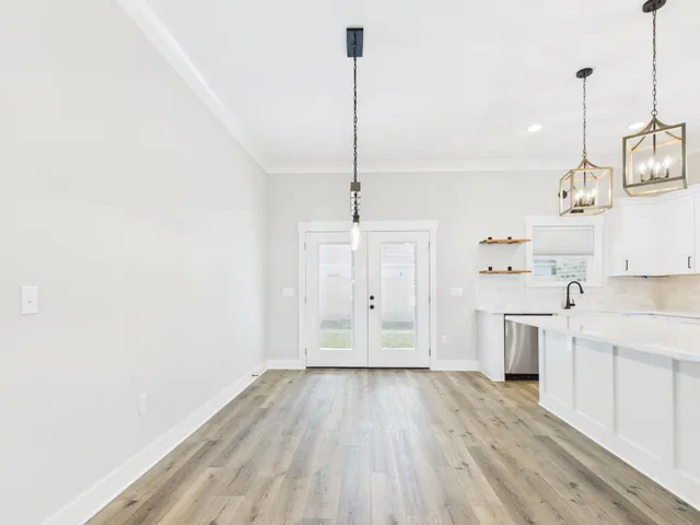 a view of a kitchen with wooden floor and stainless steel appliances