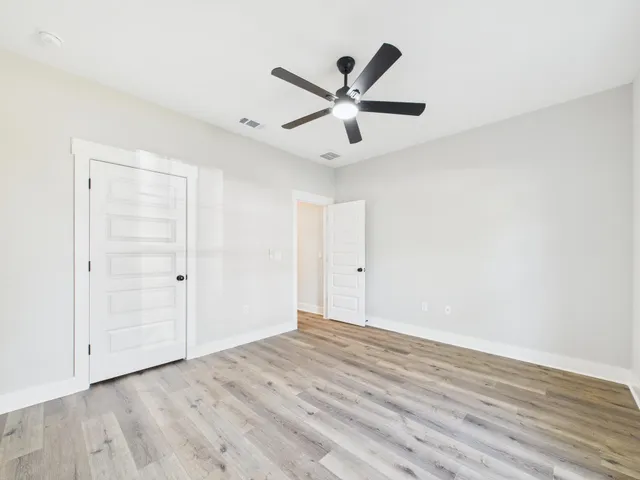 a spacious bathroom with a double vanity sink a toilet and a mirror