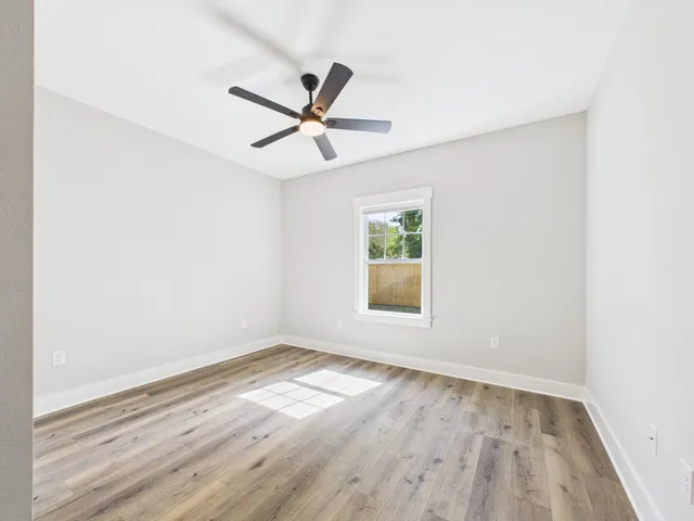 a view of a big room with wooden floor and windows