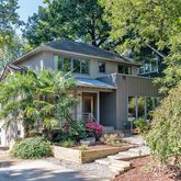 a front view of a house with a yard and potted plants