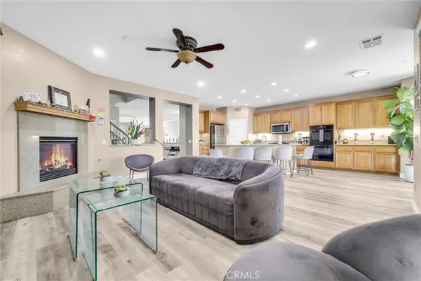 a living room with furniture kitchen view and a wooden floor