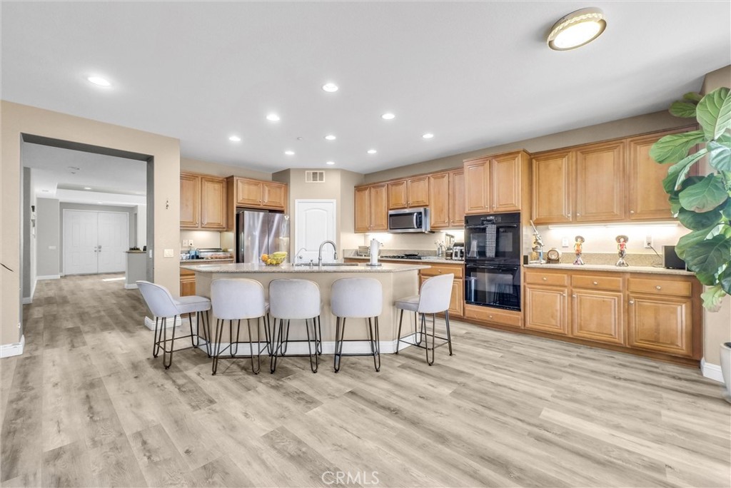 18388 Hidden Ranch Road Riverside, CA 92508 - Photo 12 of 49 a kitchen with a table chairs refrigerator and cabinets