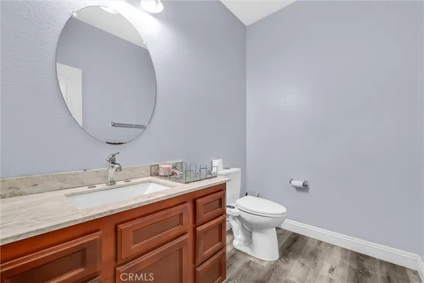 a bathroom with a granite countertop sink a toilet and a mirror