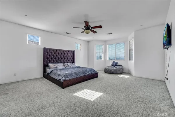 a bedroom with a bed and ceiling fan
