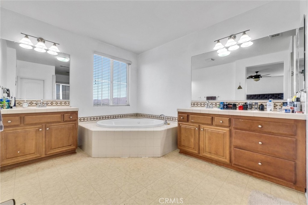 18388 Hidden Ranch Road Riverside, CA 92508 - Photo 28 of 49 a bathroom with a granite countertop bathtub a sink and a large mirror