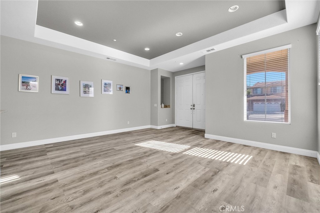 18388 Hidden Ranch Road Riverside, CA 92508 - Photo 6 of 49 an empty room with wooden floor and windows