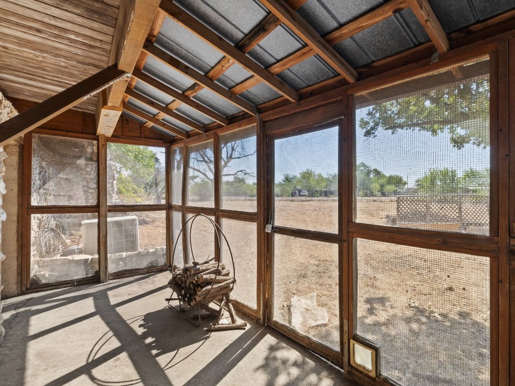 20416 Wilson Road Coupland, TX 78615 - Photo 21 of 39 Exposed wood framing and concrete flooring define this rustic screened porch looking out over the property.