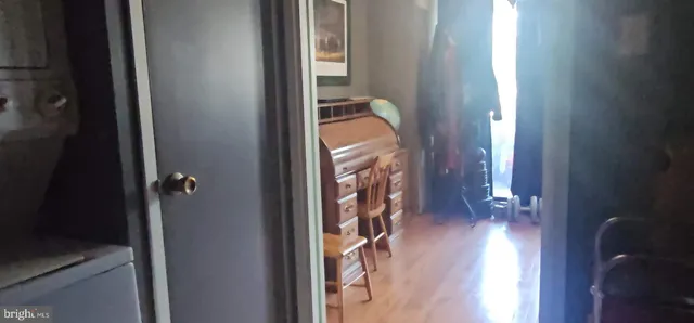 a living room with furniture a flat screen tv and a refrigerator