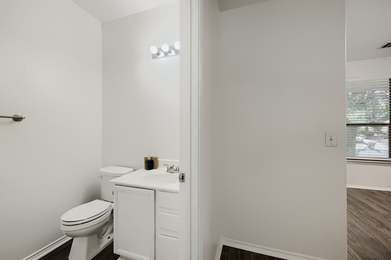 4508 Peach Grove Road Austin, TX 78744 - Photo 13 of 22 An inviting powder room features clean lines, neutral tones, and durable wood-look flooring.