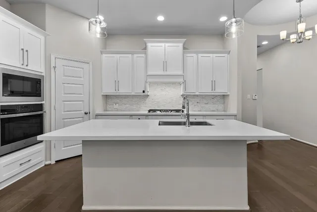 a kitchen with stainless steel appliances a sink stove refrigerator and cabinets