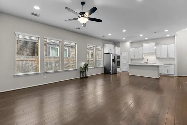 a view of an empty room with a window and wooden floor