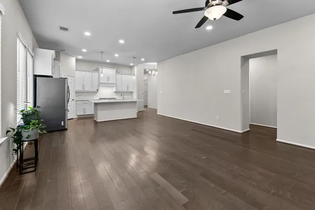 a view of a kitchen with refrigerator and wooden floor
