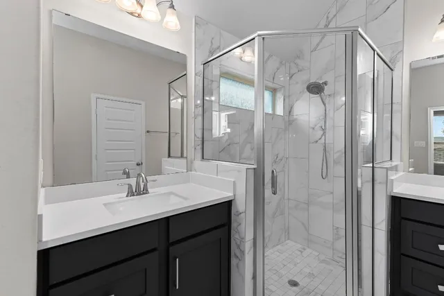 a spacious bathroom with a shower sink and mirror