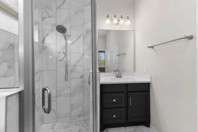 a bathroom with a shower sink and mirror