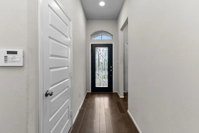 a view of a hallway with wooden floor and staircase