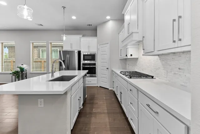 a kitchen with a sink stainless steel appliances and cabinets