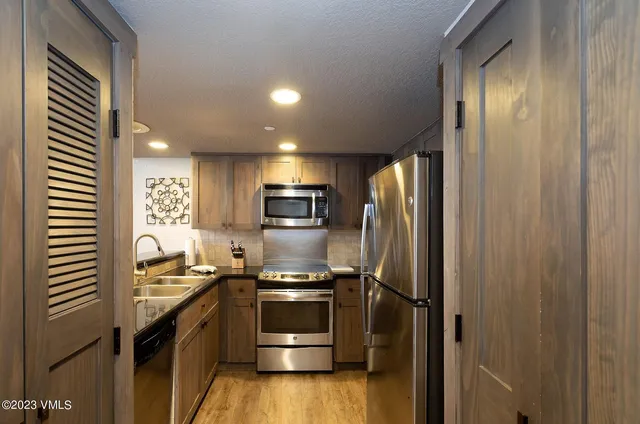 a kitchen with a refrigerator and a sink