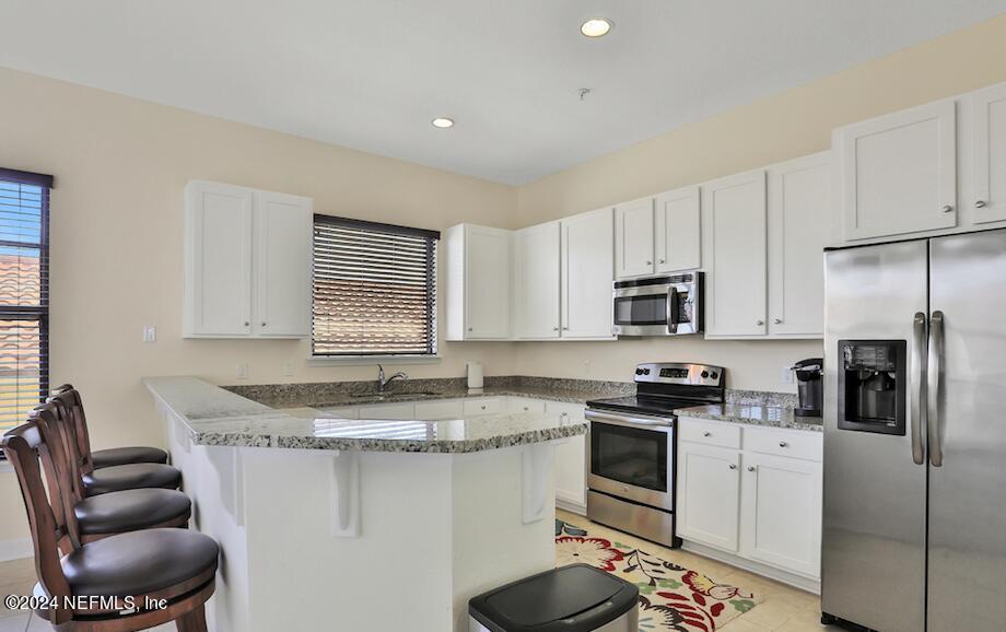 634 Market Street St. Augustine, FL 32095 - Photo 4 of 13 a kitchen with stainless steel appliances granite countertop a sink a stove a refrigerator cabinets and a window