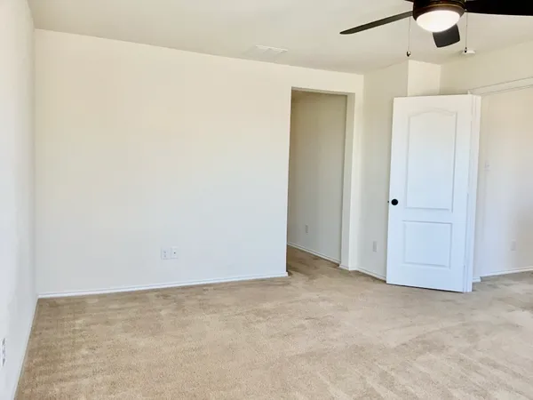 an empty room with a ceiling fan and closet