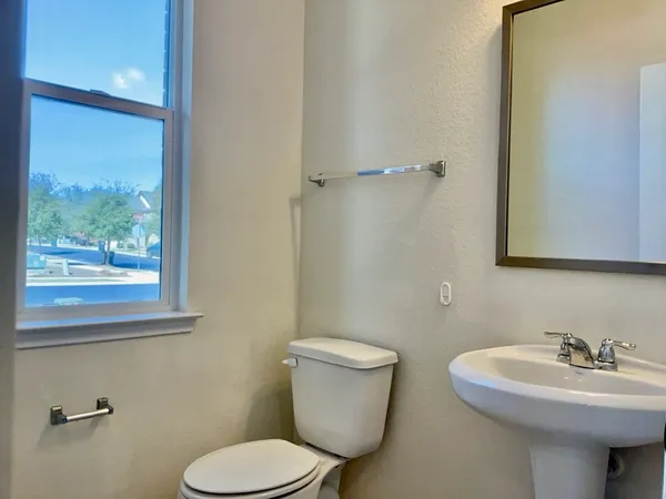 a bathroom with a sink a toilet and a mirror