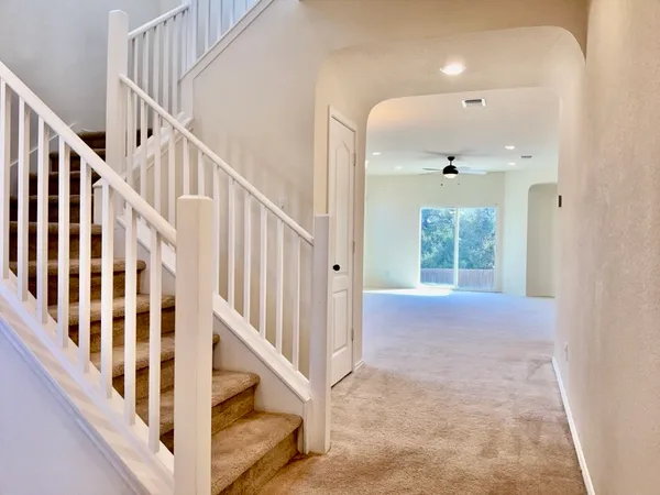 a view of staircase with lots of frames and white walls