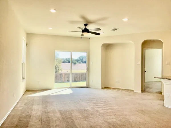 a view of a room with a ceiling fan and window