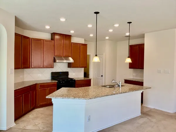 a large kitchen with kitchen island a sink stainless steel appliances and cabinets