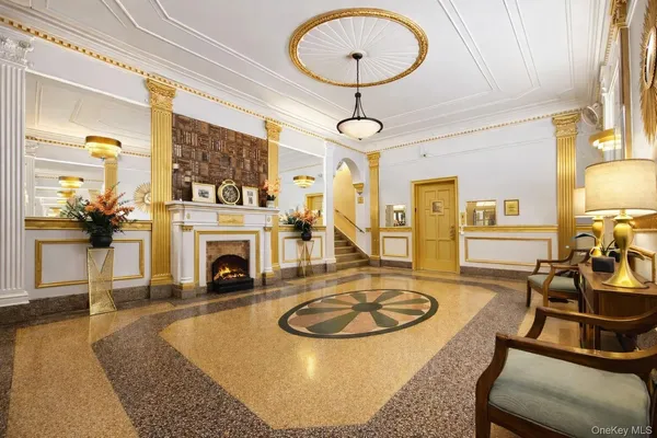 a living room with furniture a fireplace and a chandelier