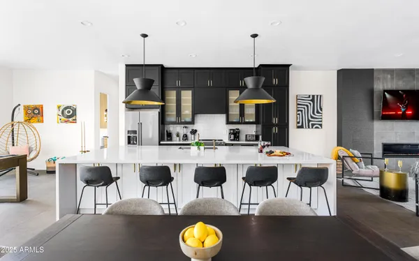 a view of kitchen with stainless steel appliances kitchen island dining table and chairs