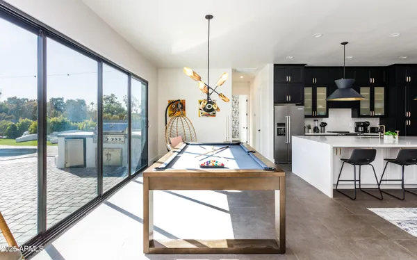 a view of kitchen with stainless steel appliances kitchen island granite countertop a table and chairs in it