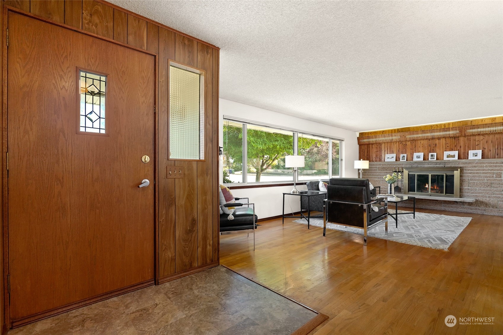 2309 Edmonds Avenue Northeast Renton, WA 98056 - Photo 3 of 35 a living room with furniture a fireplace and a floor to ceiling window