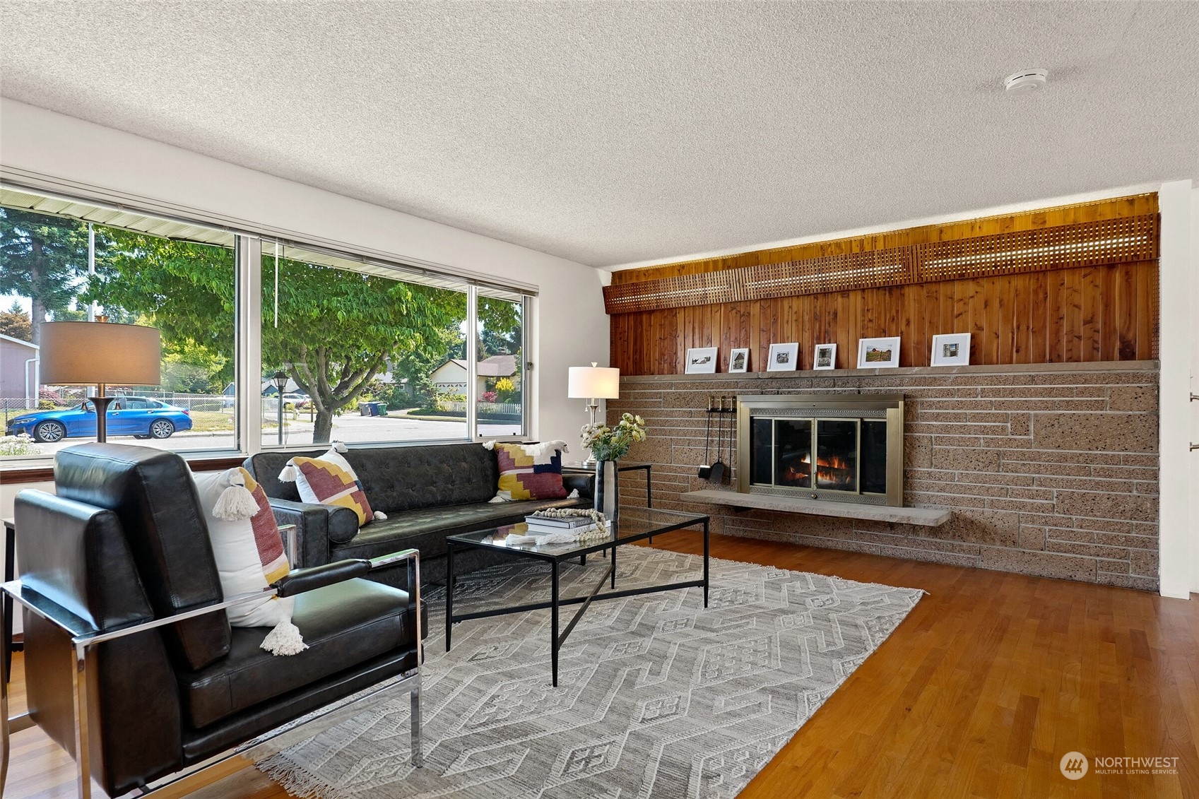 2309 Edmonds Avenue Northeast Renton, WA 98056 - Photo 4 of 35 a living room with furniture a fireplace and a floor to ceiling window