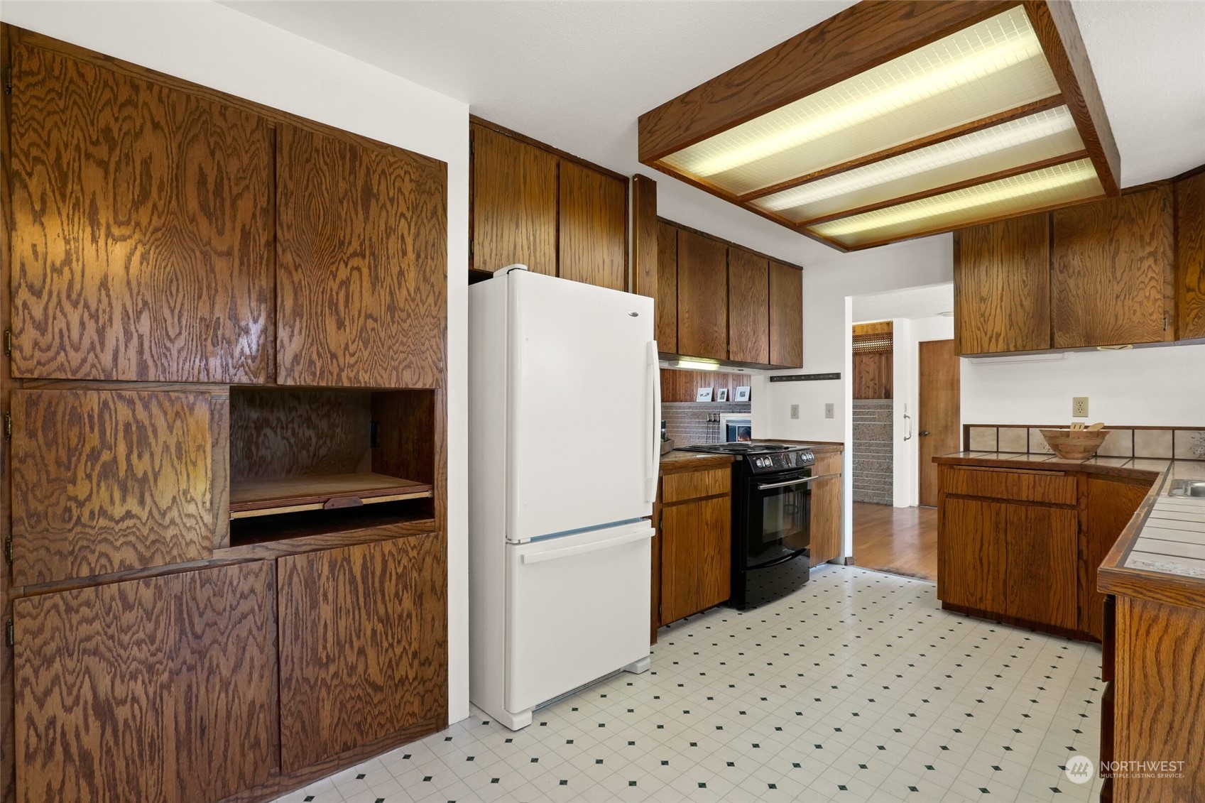 2309 Edmonds Avenue Northeast Renton, WA 98056 - Photo 10 of 35 a kitchen with stainless steel appliances granite countertop a refrigerator stove a sink dishwasher and wooden cabinets with a fireplace
