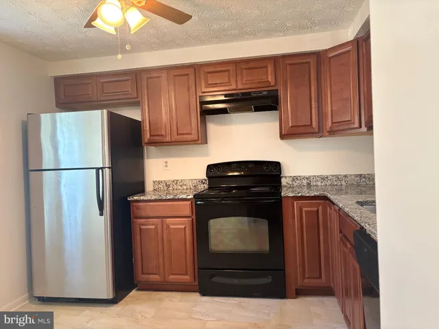 a kitchen with stainless steel appliances granite countertop a refrigerator stove and sink