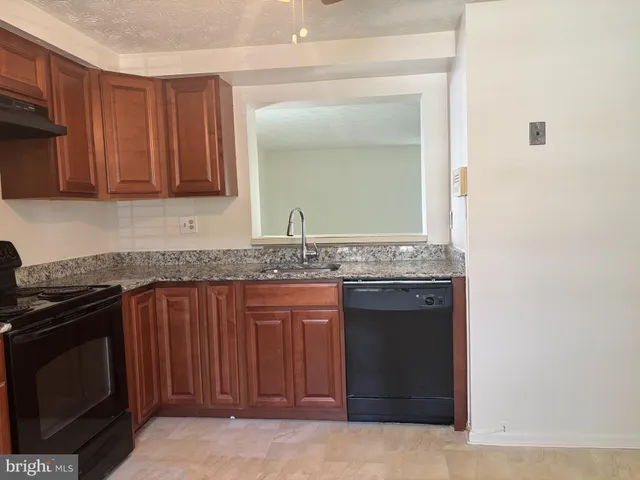 a kitchen with granite countertop a stove and a sink