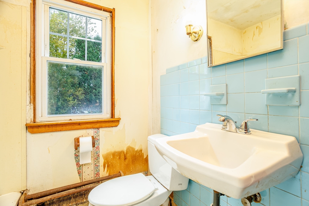 49 Bennett Street Chicopee, MA 01013 - Photo 24 of 42 a bathroom with a sink a toilet and a mirror
