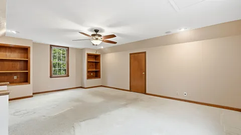 an empty room with windows and a ceiling fan