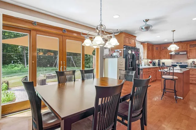 a dining room with furniture a chandelier and wooden floor