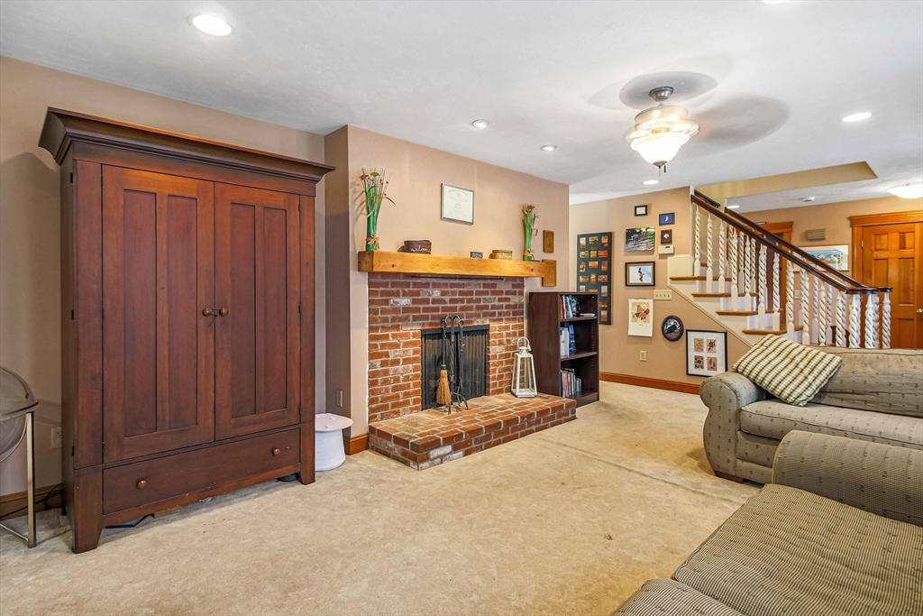 24 Manchaug Road Sutton, MA 01590 - Photo 10 of 40 a living room with furniture a fireplace and a ceiling fan