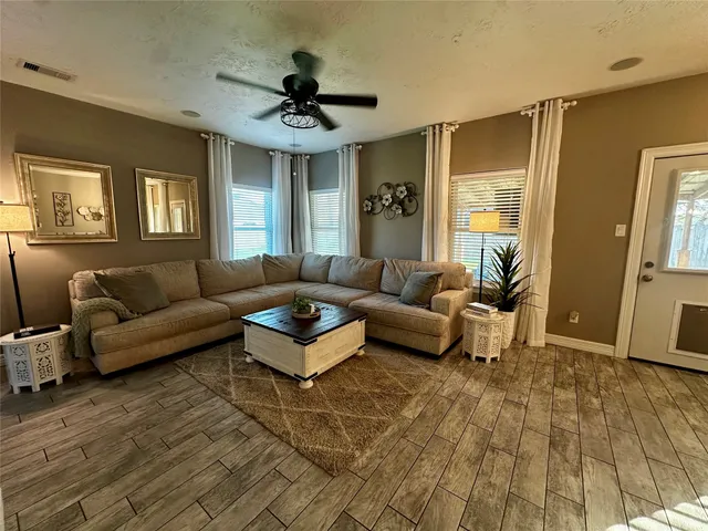 a living room with furniture and a wooden floor