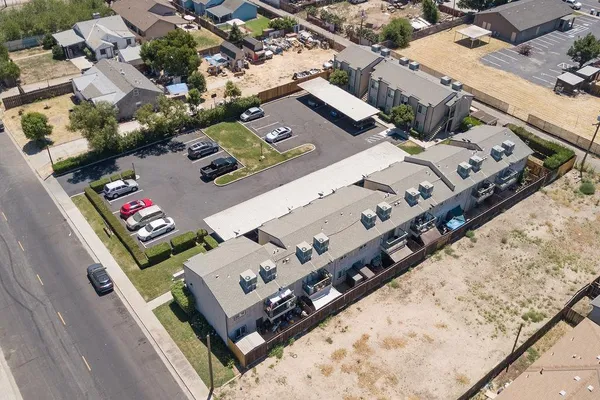 an aerial view of residential houses with outdoor space and parking