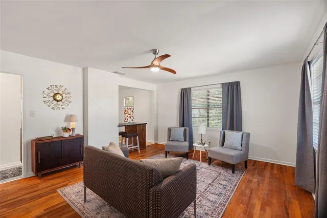 a living room with furniture and wooden floor