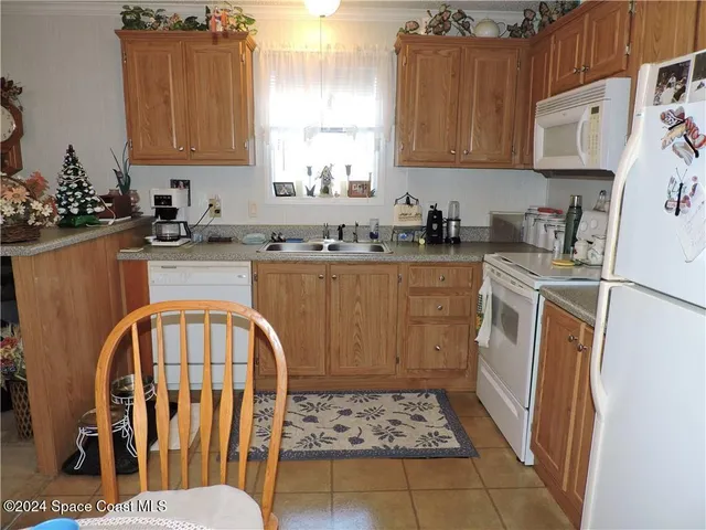 a kitchen with stainless steel appliances granite countertop a stove a sink dishwasher and a refrigerator with wooden cabinets