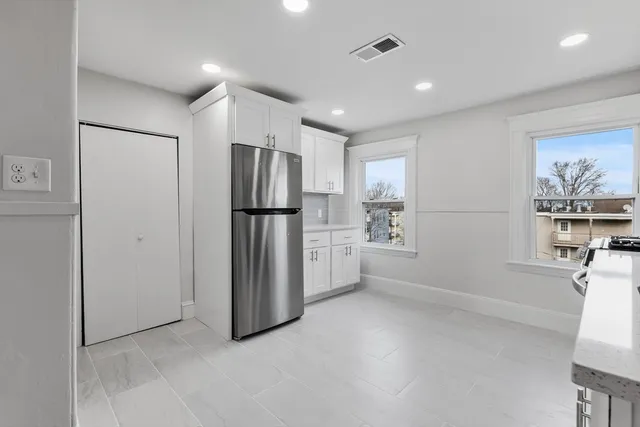 a view of kitchen with refrigerator cabinets and wooden floor